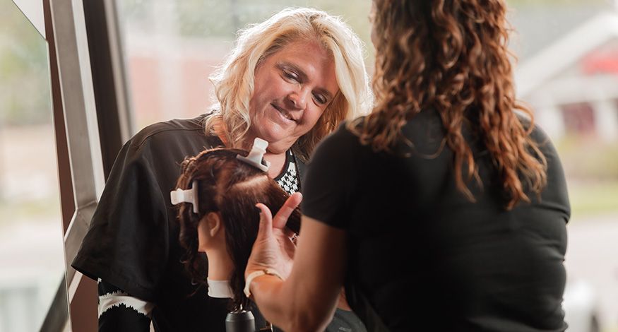 Instructor Smiling at Student's Work on Mannequin