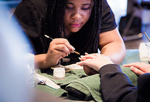 Woman Applying Acrylic to Nails